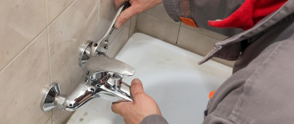Professional plumber adjusting shower handle in Fish Hawk, FL.